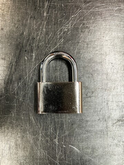 Fototapeta premium Metallic padlock on metal texture background