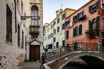Fototapeta na wymiar Scenic canal with bridge and ancient buildings with potted plants in Venice, Italy