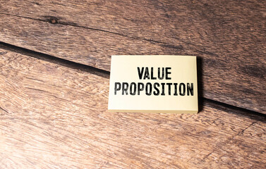 VALUE PROPOSITION text on notebook with pen and pencil on a grey background.