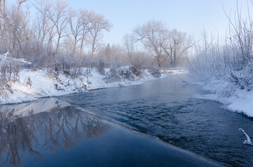 Fast river on a frosty winter morning. Winter atmosphere of dawn.