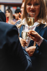 A diverse group of adults celebrates their business achievements with a lively and successful party. They toast to accomplishments, success, and a fruitful partnership.