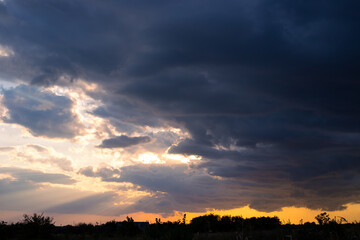 Heavy dark blue autumn clouds over a rural field. Bad weather, cloudy weather with a rainy cloud