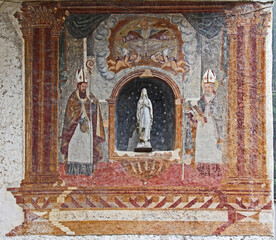 Madonnina in una nicchia a Forno, frazione di Moena in Val di Fassa; nell'affresco, Dio Padre e due Vescovi