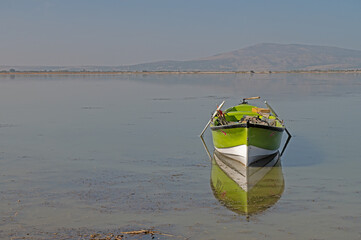Green coloured fishing boat on the lake.