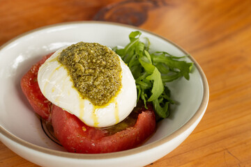 Burrata con jitomate, pesto y arúgula 