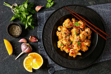 crispy orange cauliflower florets in black bowl