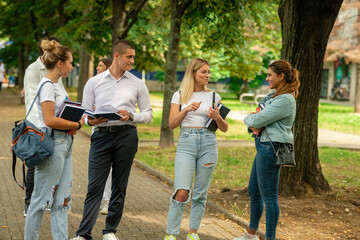 Young high school students talking and studying outside in the schoolyard