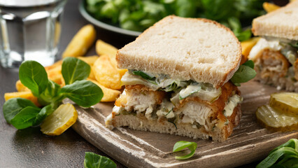Fish Finger Sandwich on wooden board with potato fries