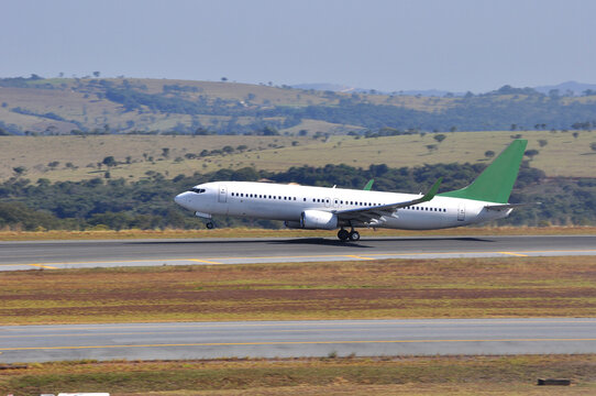 voo comercial de passageiros com avi&atilde;o em movimento e decolando, elevado &agrave; pista de voo do aeroporto de uma grande cidade