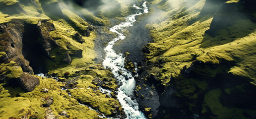 Breathtaking aerial view of a winding river through lush green valleys, flanked by majestic mountain ranges. The natural beauty of this untouched landscape evokes a sense of serenity.