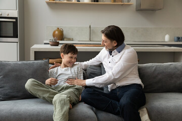 Joyful dad tickling excited teenage son kid, cuddling child with love, tenderness. Father and teen...