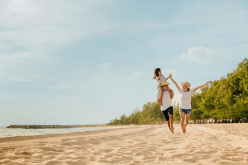 World Tourism Day. Happy people having fun in summer vacation on beach, Family traveling in holiday running race at sand beach, Dad, mom and child daughter enjoying road family trip playing together © sorapop