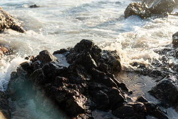 Sea waves breaking on the beach rocks.
