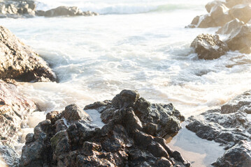 Sea waves breaking on the beach rocks.