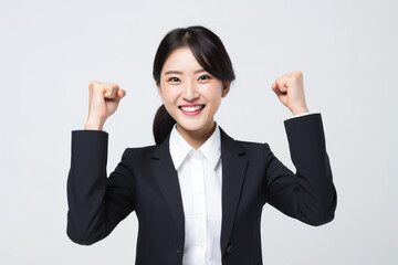 Cool looking young Asian businesswoman raising his fists in success and joy , isolated on white background.