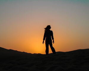silhueta de mulher em por do sol nas dunas de huacachina, peru 