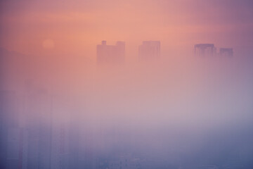 Sunrise over Daegu City skyline, tips of the skyscrapers floating over the morning fog and smog in South Korea, minimalist impressionistic photo