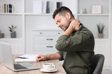Fototapeta premium Man suffering from neck pain in office