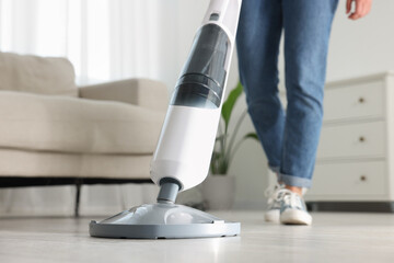 Woman cleaning floor with steam mop at home, closeup - obrazy, fototapety, plakaty