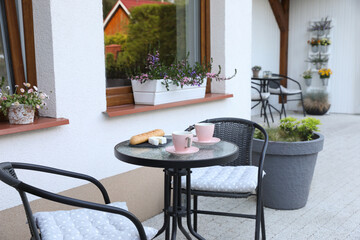 Cups of coffee, bread and cheese on glass table. Relaxing place at outdoor terrace