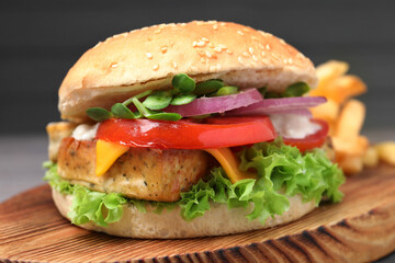 Delicious burger with tofu and fresh vegetables on wooden board, closeup