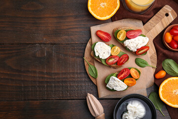 Delicious sandwiches with burrata cheese and tomatoes served on wooden table, flat lay. Space for text