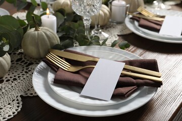 Beautiful autumn table setting. Plates, cutlery, blank cards and floral decor