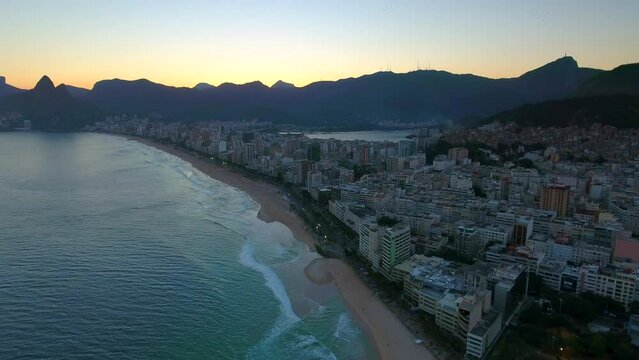 Aerial Panning Shot Of Buildings At Ipanema Beach Near Sea And Mountains Against Sky At Sunset - Rio de Janeiro, Brazil