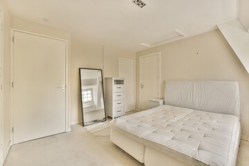 a bedroom with a bed, dresser and mirror in the corner of the room on the left is a closet