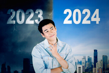 Young man thinking and hoping next year 2024 will be a better year