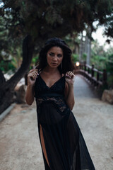 Naklejka premium Beautiful woman at the bridge between palms at the evening 