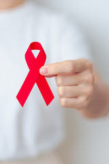 woman with Red Ribbon for December World Aids Day, acquired immune deficiency syndrome, multiple myeloma Cancer Awareness month and National Red ribbon week. Healthcare and world cancer day concept