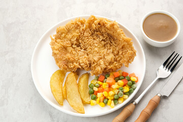 Crispy Chicken Steak with french fries and vegetables. 
