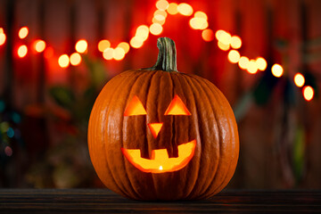 Halloween. Happy Jack o lantern face.
Pumpkin on Halloween party. Smiling Jack-o'-lantern. Candle Lights. Decoration Idea for home, house on halloween. Autumn, fall season. Wooden fence on background