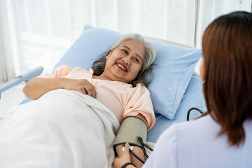 Obraz premium Daily inspection A nurse or caregiver of an elderly patient measures the patient's blood pressure and heart rate.