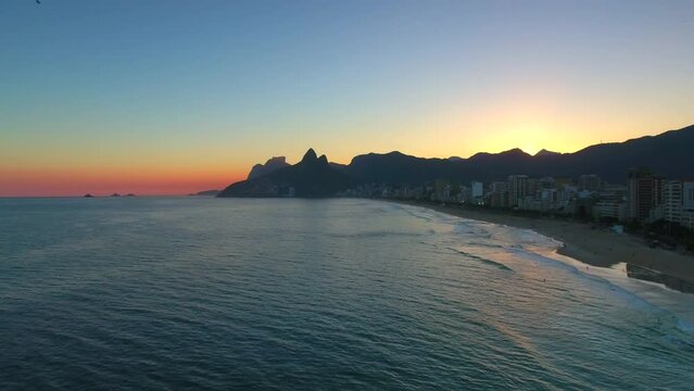 Aerial Panning Shot Of Ipanema Beach Near City And Mountains Against Sky At Sunset - Rio de Janeiro, Brazil
