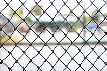 Fototapeta premium Black netting in plastic blocks the area of the football stadium.