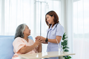 Nurse encourages elderly Asian patient and gives advice on self-care