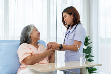 Nurse encourages elderly Asian patient and gives advice on self-care