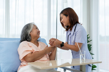 Nurse encourages elderly Asian patient and gives advice on self-care