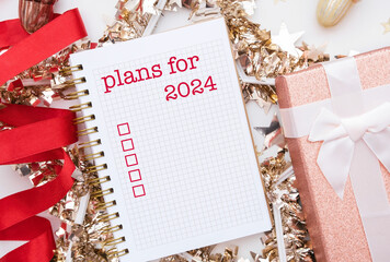 Mock up of notepad or copybook with written text - plans for 2024. Check box to do
