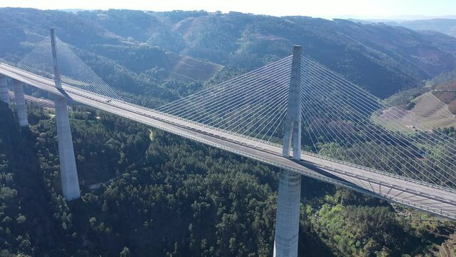 Drone view of picturesque spring landscape with mountains covered with green forests in Vila Real district in Portugal and high modern suspension viaduct 