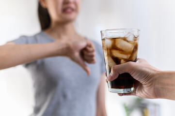 Dieting or good health concept. Young woman rejecting Junk food or unhealthy food such as sweet soda drink and choosing healthy food such as fresh fruit or vegetable.