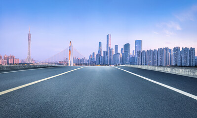 Asphalt road and city commercial buildings skyline in Guangzhou at dusk