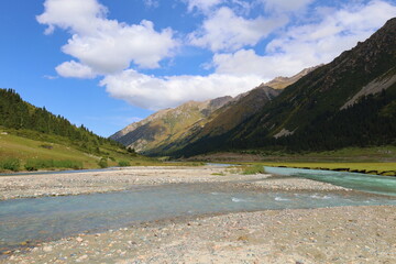 Turgenaksu valley with a river wading on a second stage of Ak-Suu Traverse trek in Karakol,...