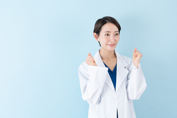 ガッツポーズする女性の医者・ブルーバック
