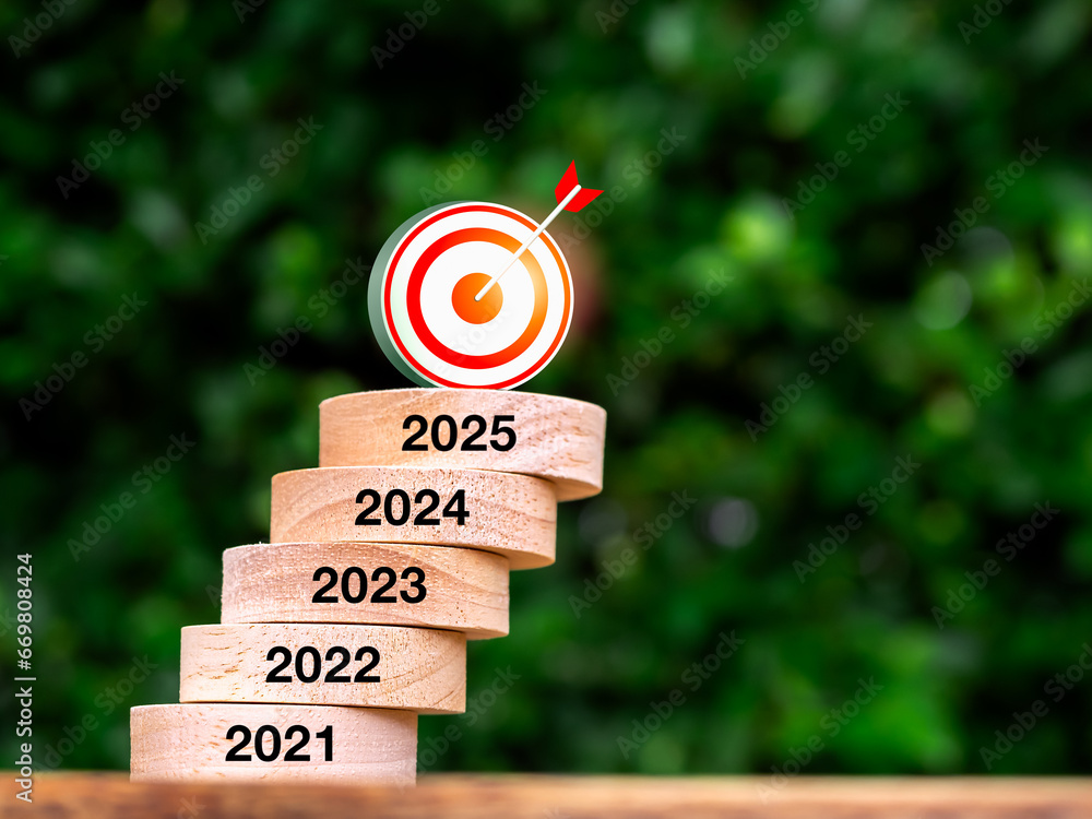 Aufkleber 3d target icon on wood block stack growth graph step with year numbers on wooden table. 2021 to 2025