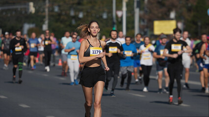 Female jogger run marathon. Thin girl work out. Woman runner jog long distance. Finish line road....