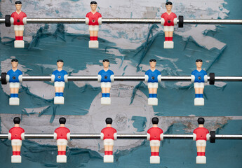 An old plastic football game with figures on sticks. The figures hang like puppets over the...