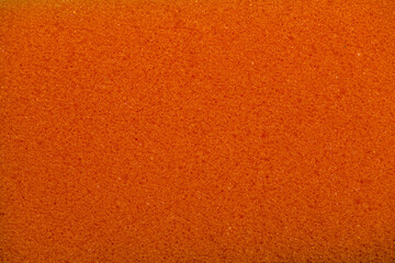 Sponge texture background. Close-up of orange bath sponge with porous structure for background....